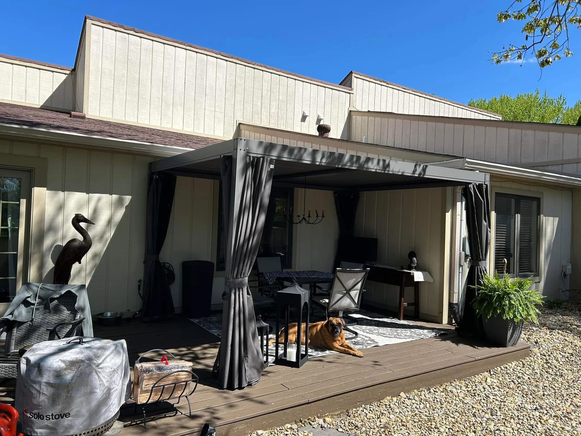 Cleaned and painted covered deck furnished with outdoor seating, dining furniture, and décor