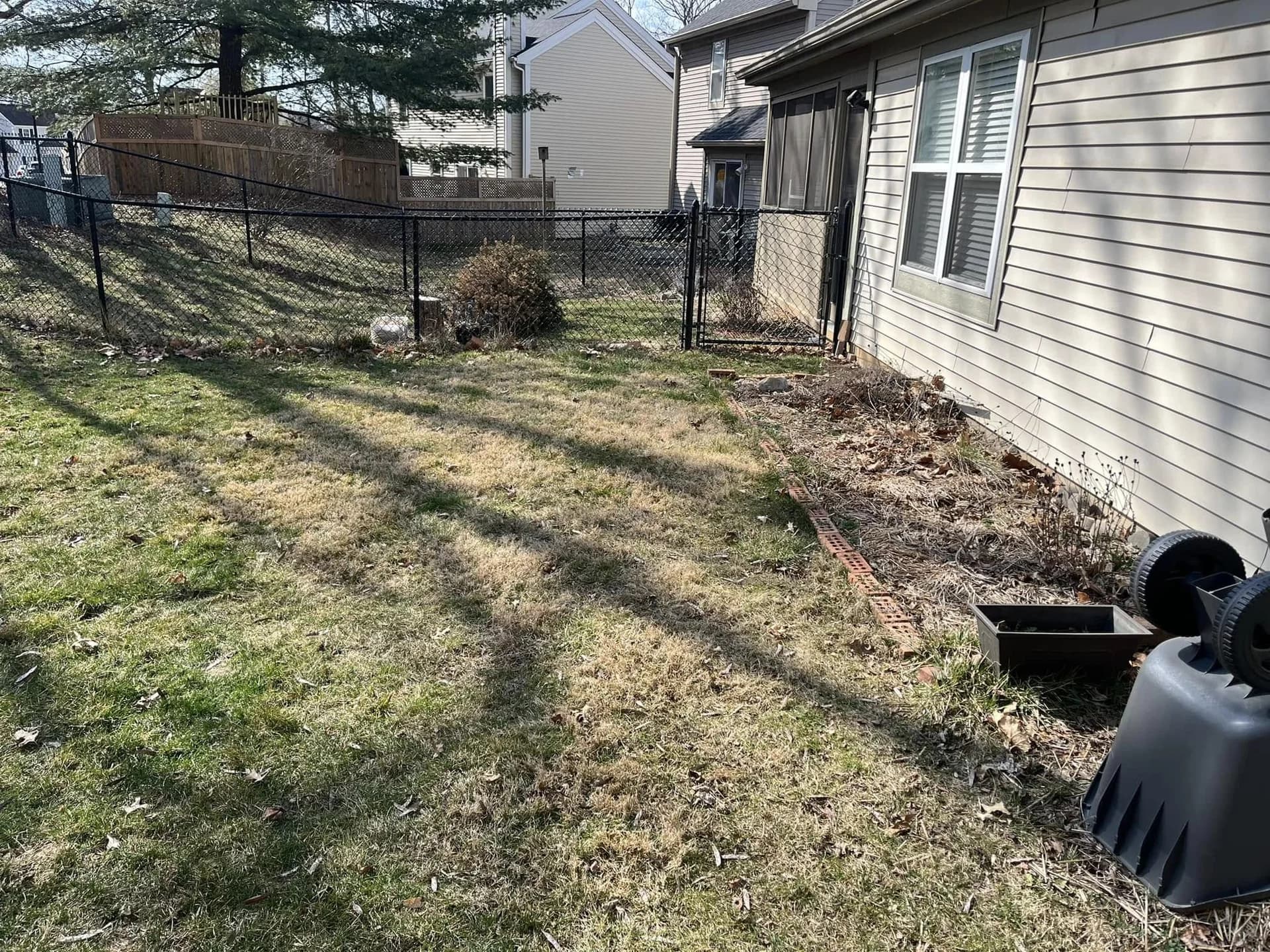 Sloped backyard lawn before construction of a flagstone patio and retaining walls