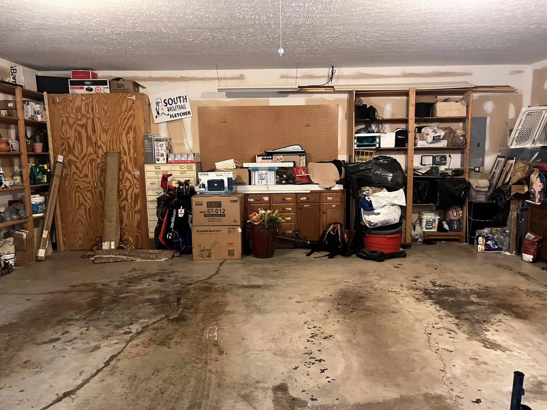 Stained and cracked concrete garage floor before restoration and coating