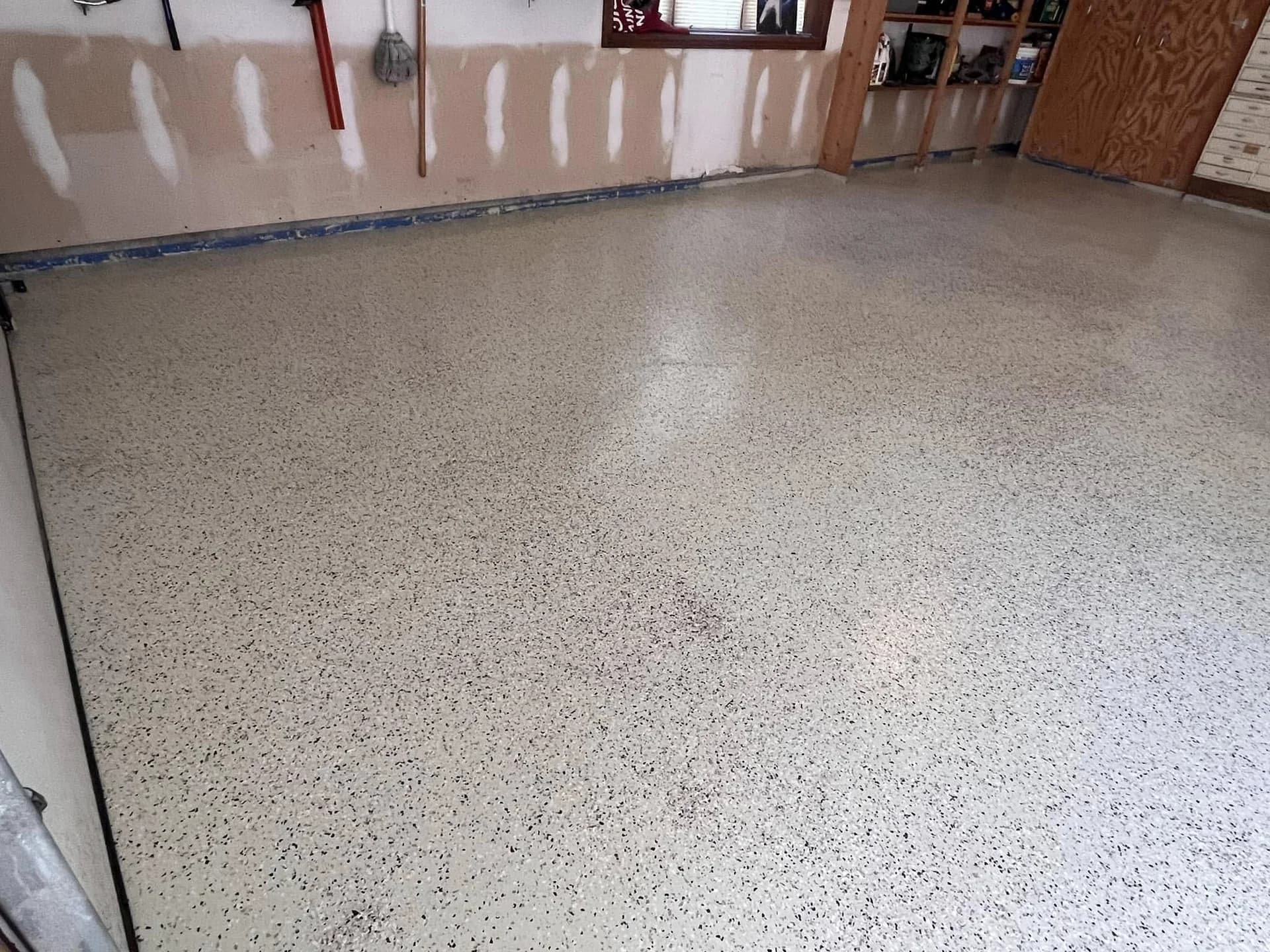 Finished garage floor with a light gray decorative flake coating
