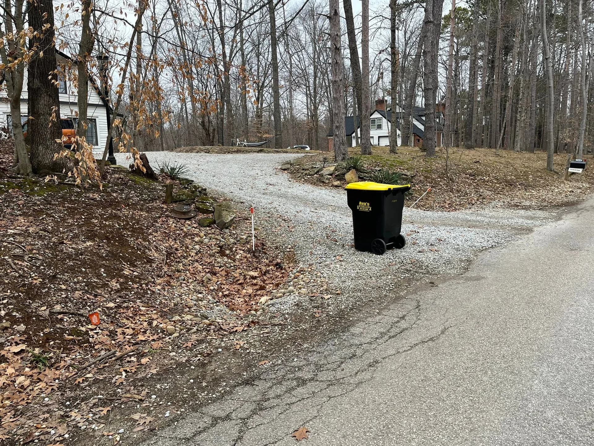 Wooded gravel driveway entrance before limestone retaining walls were installed